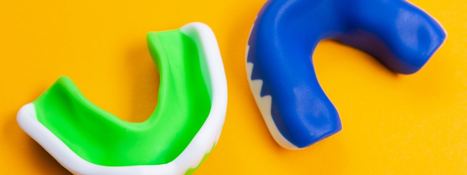 Colourful Custom made Mouthguards on yellow background.
